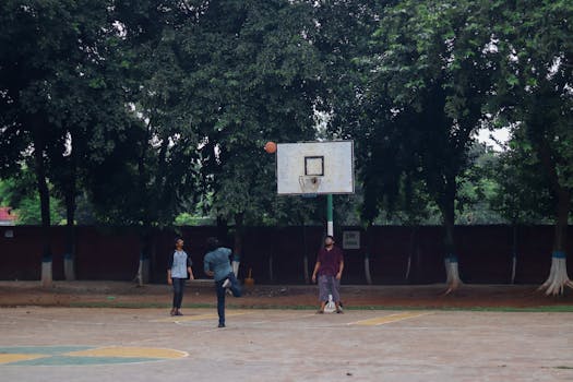 A group of young men enjoying a casual basketball game outdoors.