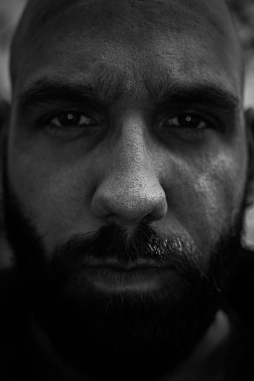 Free Close-up black and white portrait of a serious bearded man, capturing intense expression. Stock Photo
