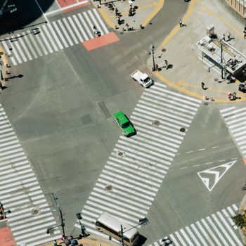 Bird's-eye view of the iconic Shibuya Crossing in Tokyo, Japan with minimal traffic and pedestrians.