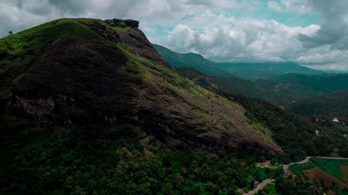 Free Scenic aerial shot of a green mountain under a cloudy sky, capturing the summer landscape. Stock Photo