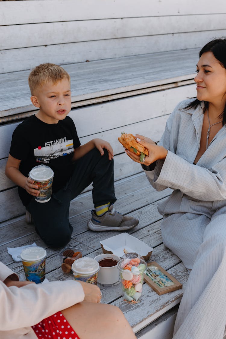 Woman Having Picnic On Wooden Bleachers With Son