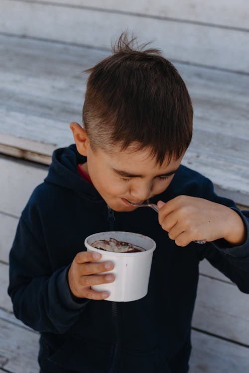 Young Boy Eating Ice Cream from Cup