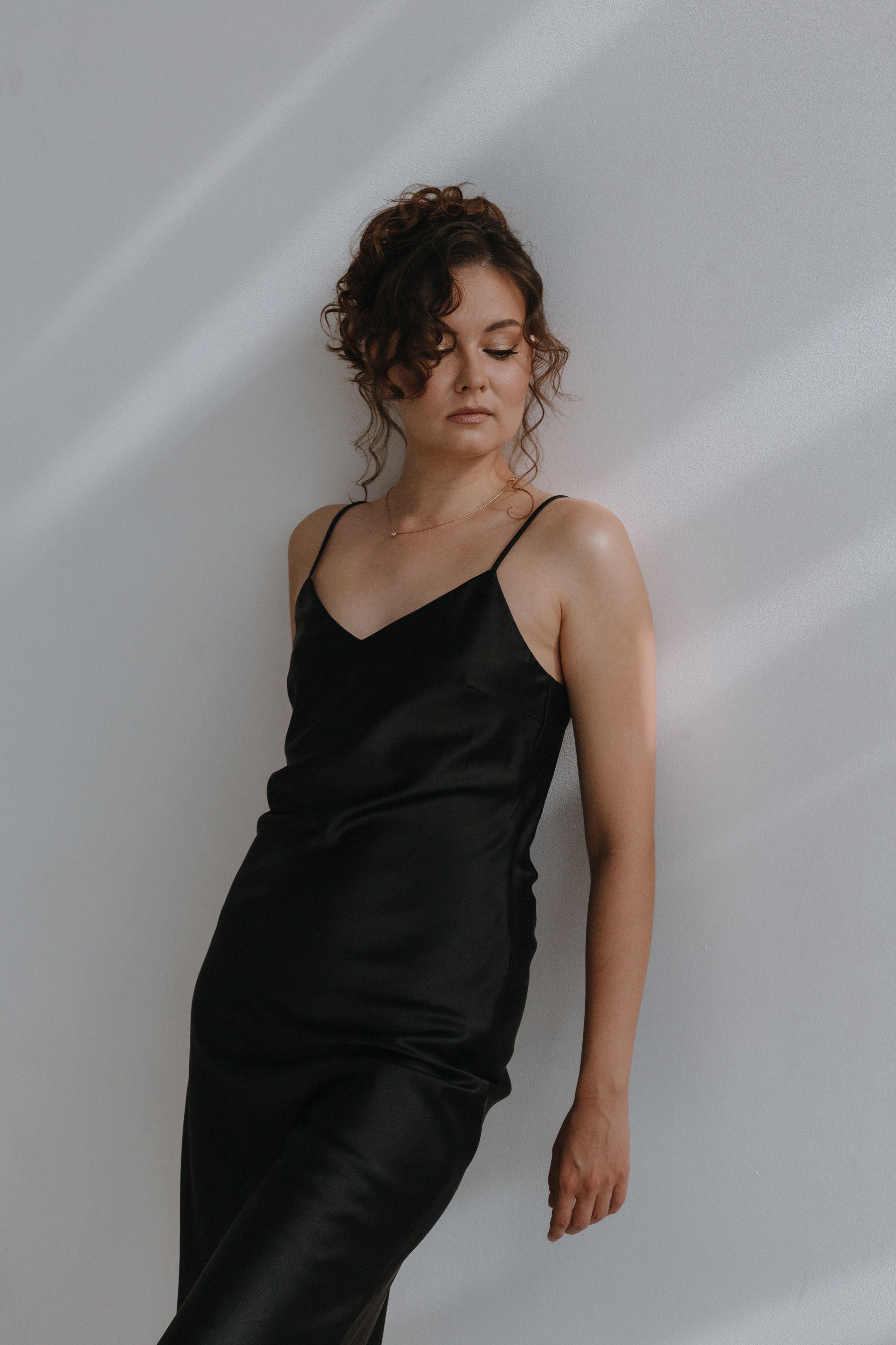 Young Woman in a Black Dress Standing against the Wall · Free Stock Photo