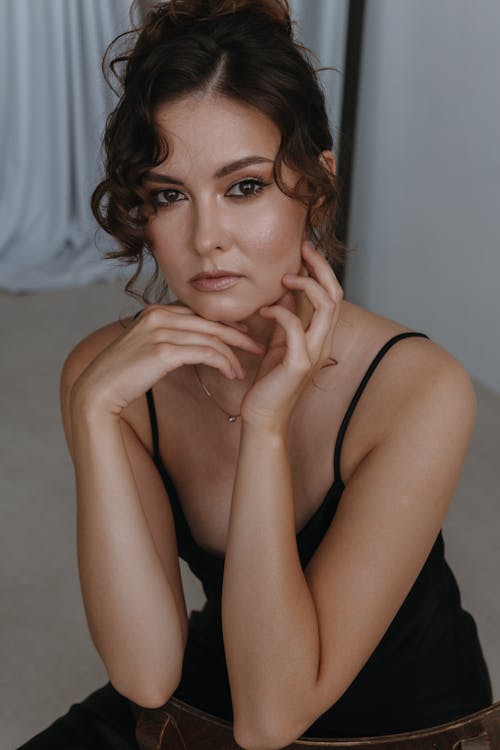 Young Woman in a Black Dress and Glamour Makeup Look Posing 
