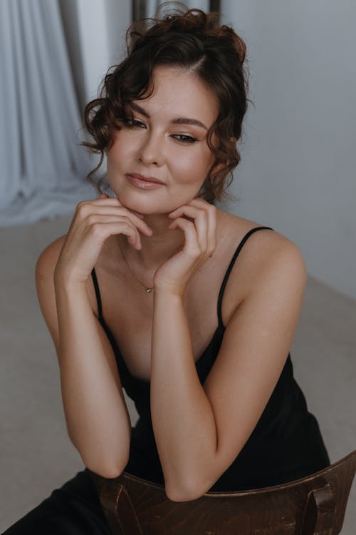 Smiling Woman in Spaghetti Straps Dress Sitting Backwards