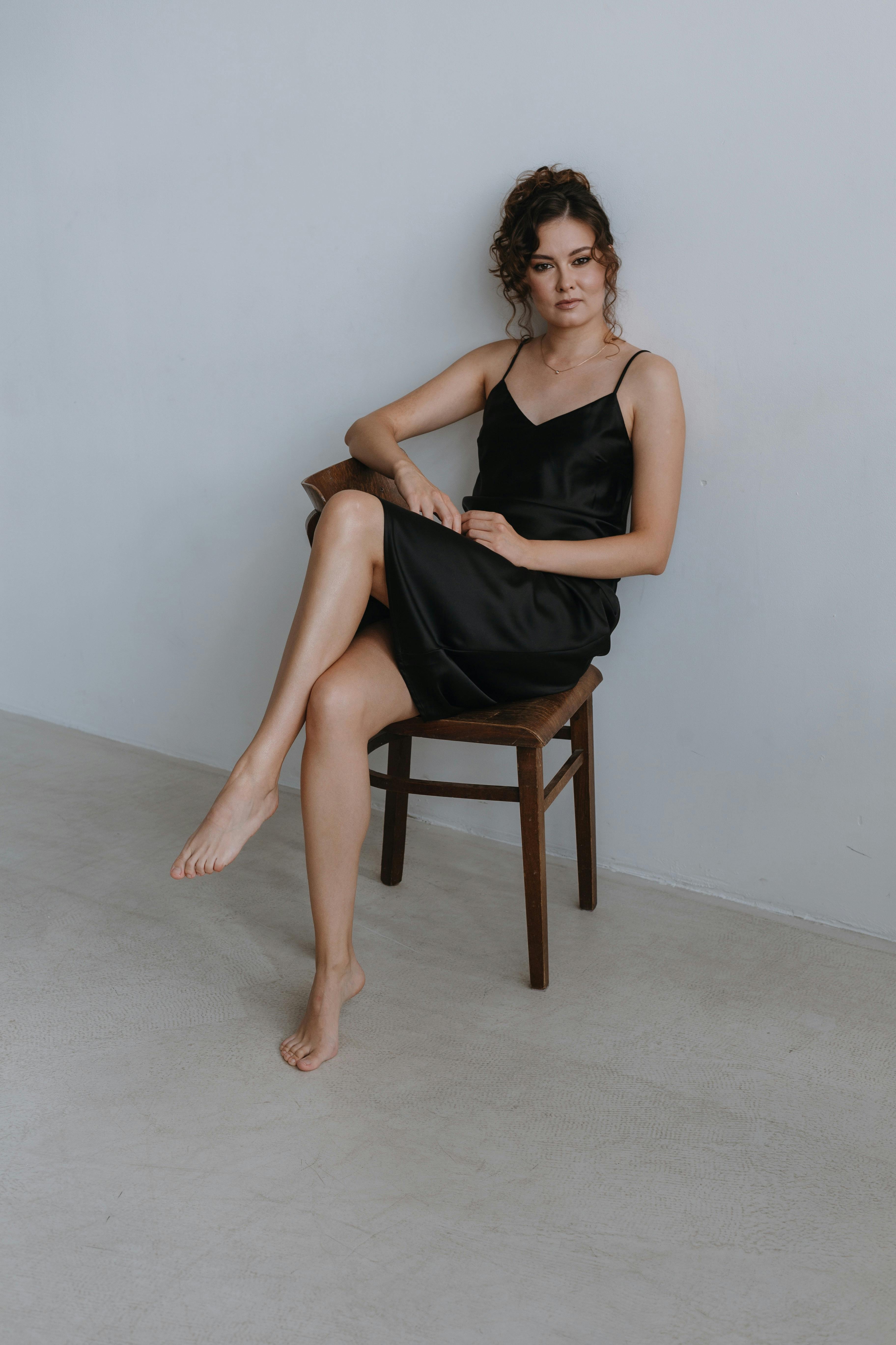 Barefoot Woman in Black Dress Sitting on Stool · Free Stock Photo