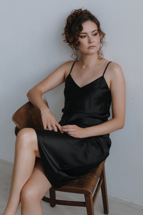 Elegant Woman in a Black Dress Sitting on a Chair 