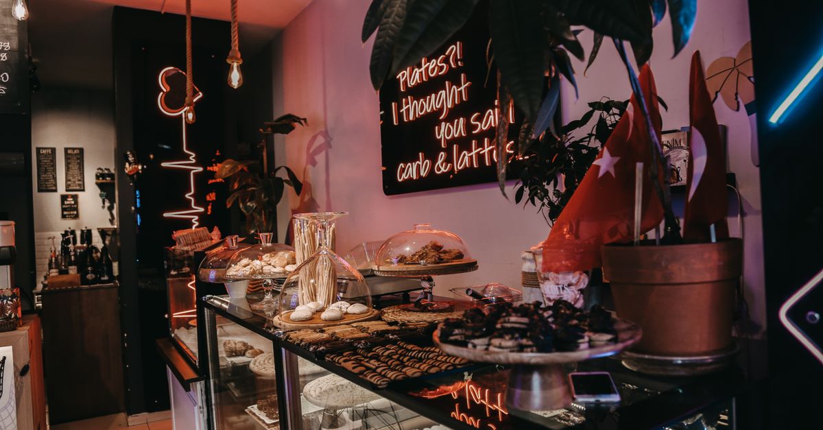 Inviting café display showcasing a delicious assortment of pastries and sweets with cozy décor and lighting.