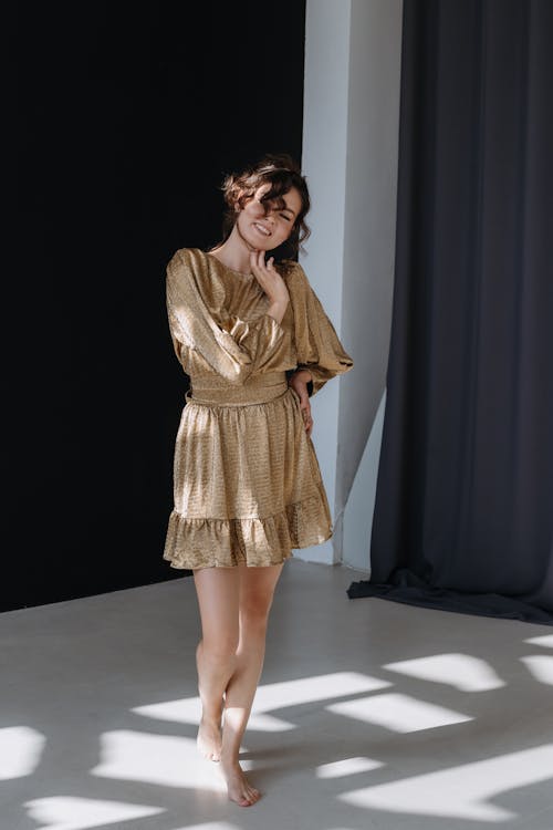 Young Brunette Woman Posing in Golden Mini Dress 