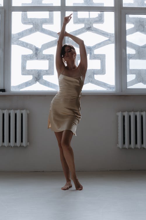 Woman in Silk Spaghetti Strap Dress Standing in Seductive Pose