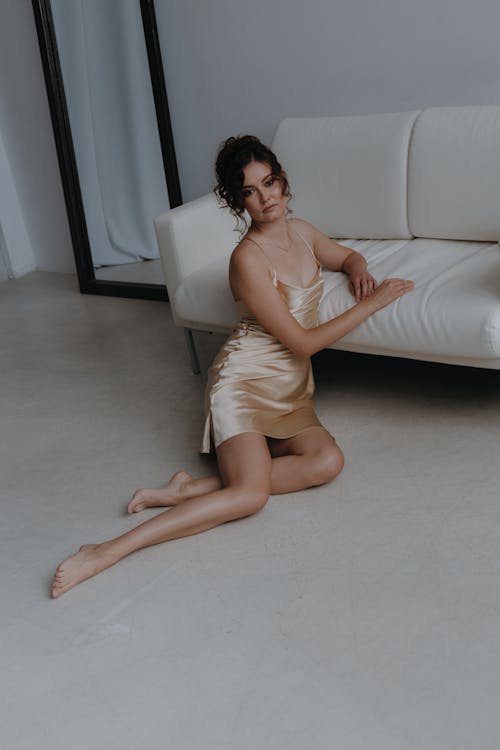 Woman in Spaghetti Strap Dress Sitting on Floor and Leaning on Sofa
