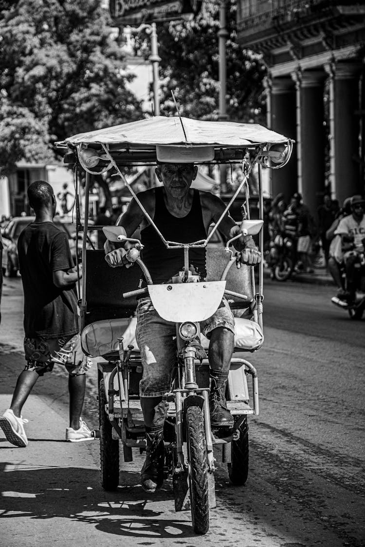 Elderly Man Riding Motorbike On Street