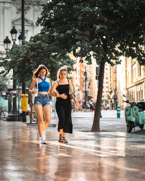 Two Young Women Walking through City in Summer