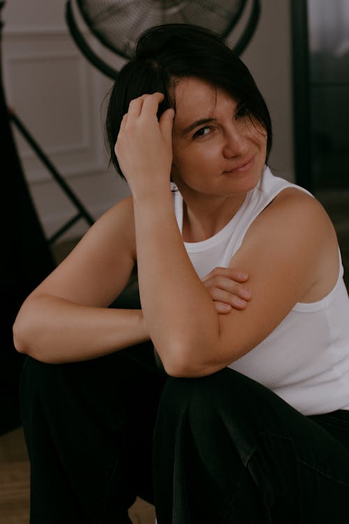 Brunette Woman Posing in White Tank Top and Black Pants