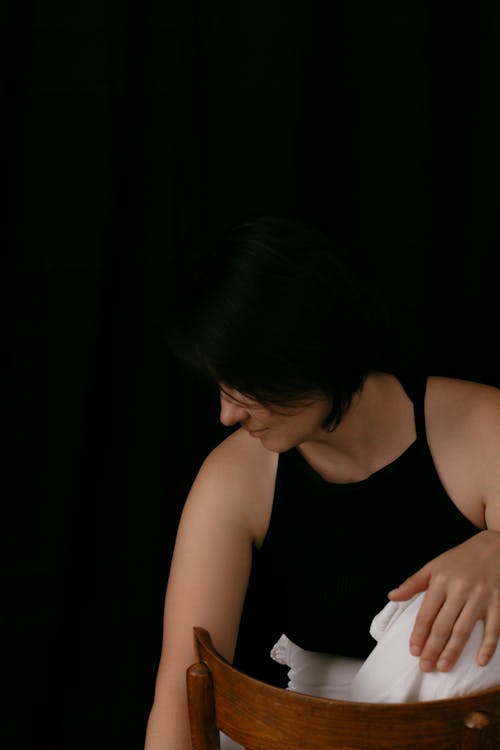 Woman in a Simple Outfit Sitting on a Chair 