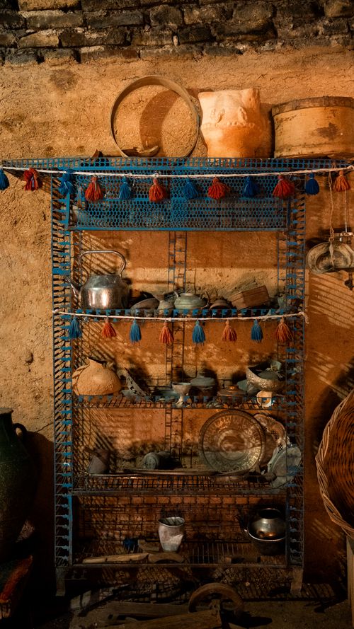 Free A collection of rustic kitchenware displayed on a traditional shelf made of metal in a rural setting. Stock Photo