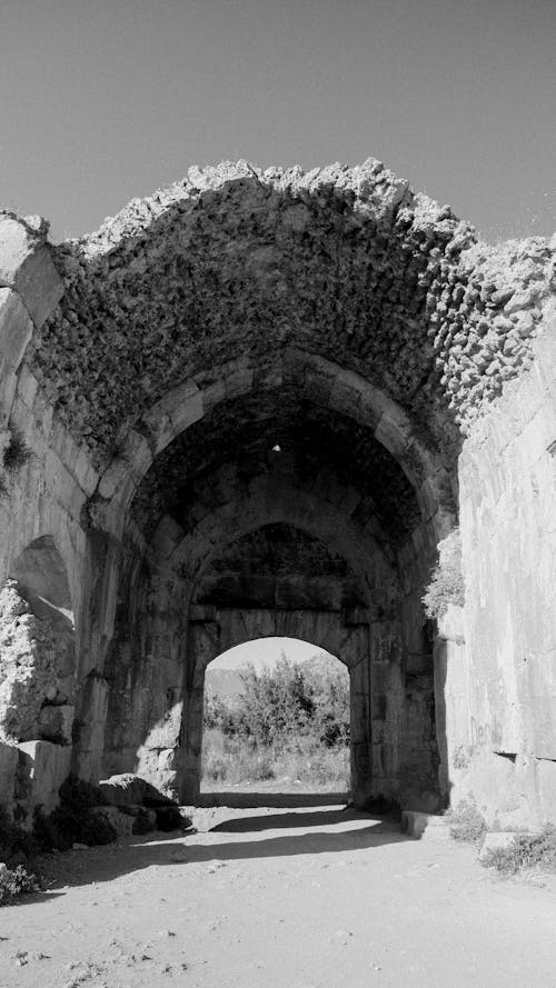Black and White Picture of an Arch in the Ruins of a Building 
