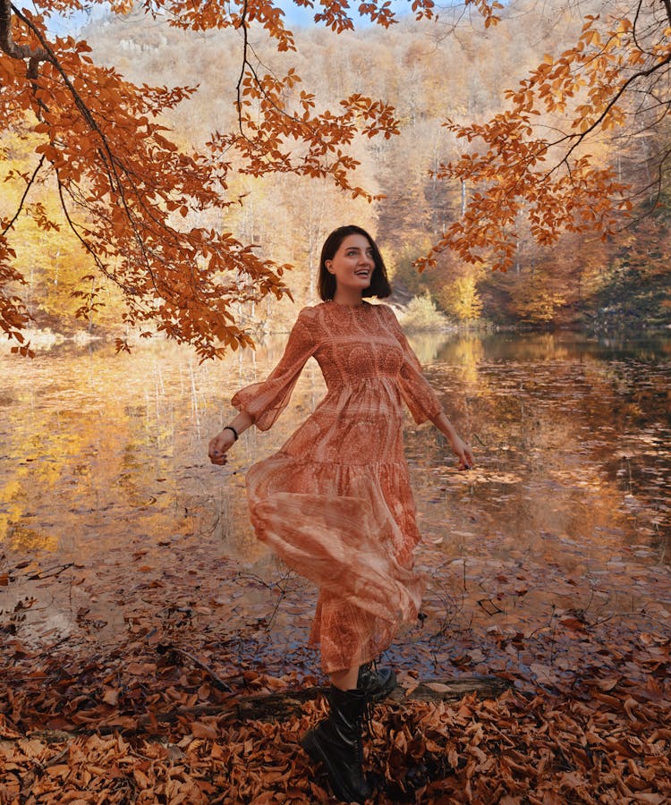 Woman In Dress Posing In Water In Forest In Autumn