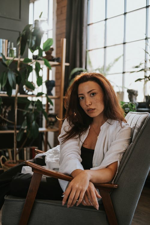 Woman in Shirt Sitting on Armchair