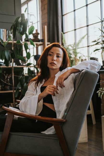 A woman in a modern armchair amidst houseplants in a stylish Baku interior.