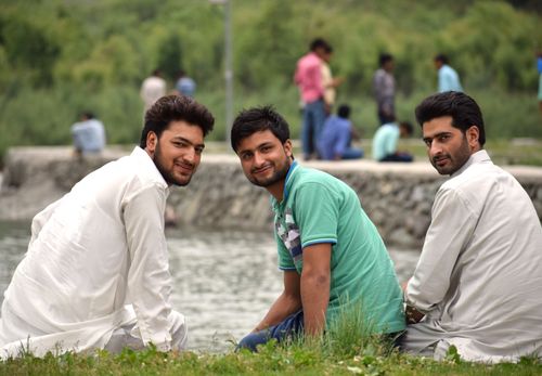 Free Three friends enjoying leisure time by the river during summer. Stock Photo