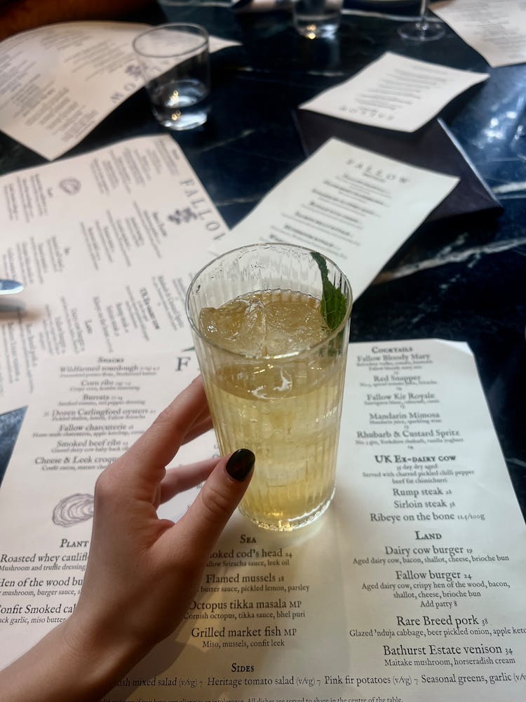 Womans Hand Holding A Drink In A Restaurant