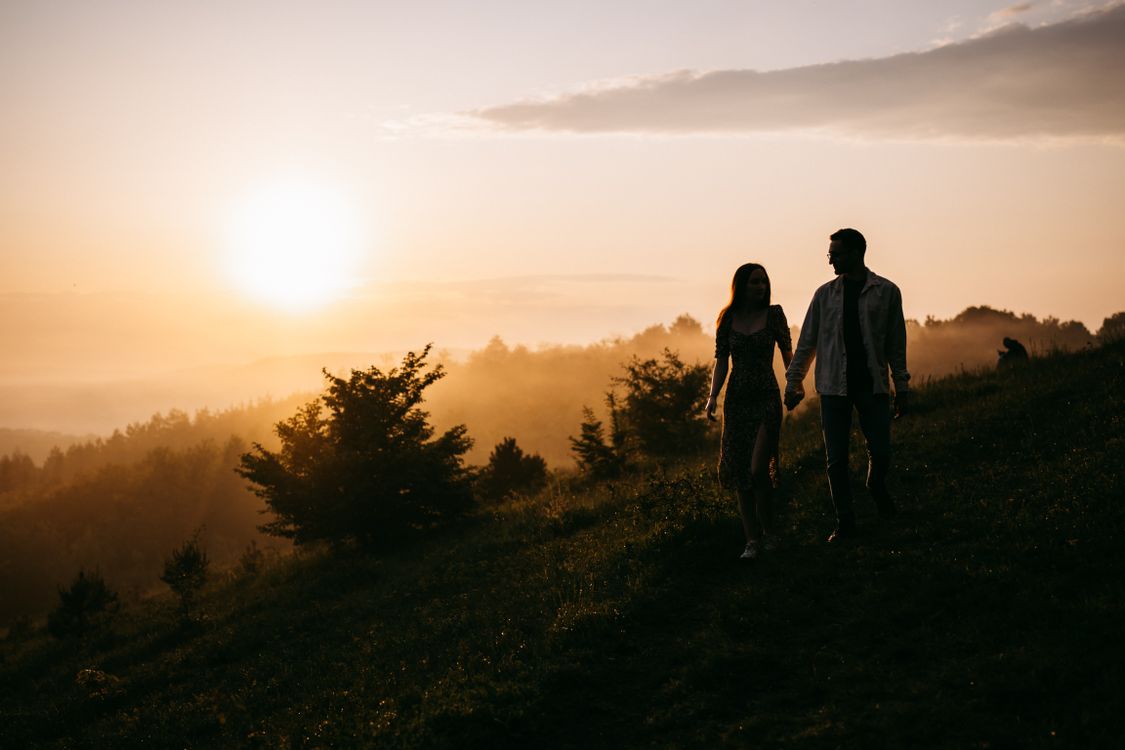 Couple Holding Hand by the Sunset on the Peak of a Hill · Free Stock Photo