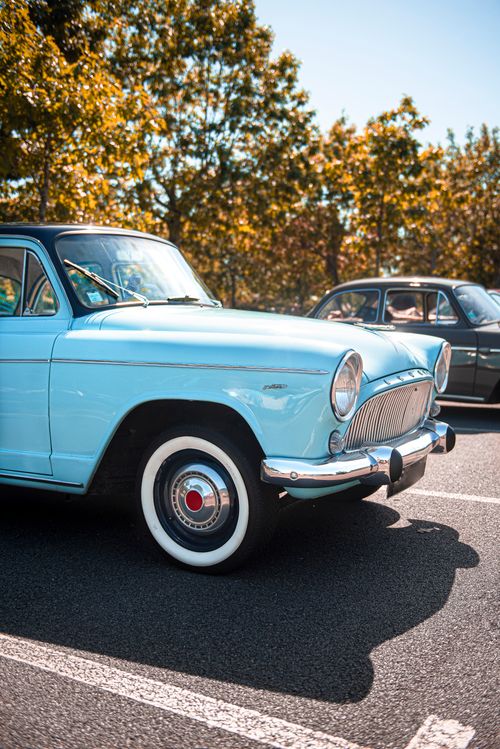 Free A classic vintage car parked in a sunlit autumn setting, showcasing retro charm. Stock Photo
