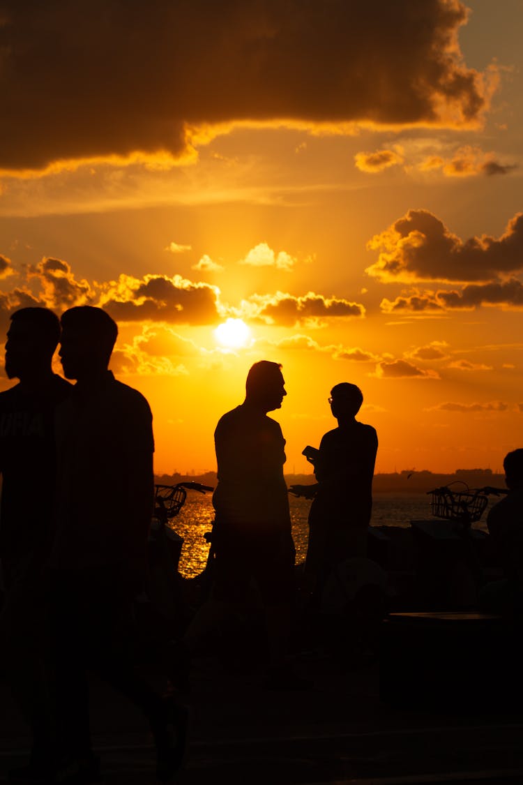 Silhouettes Of People On A Beach During Sunset