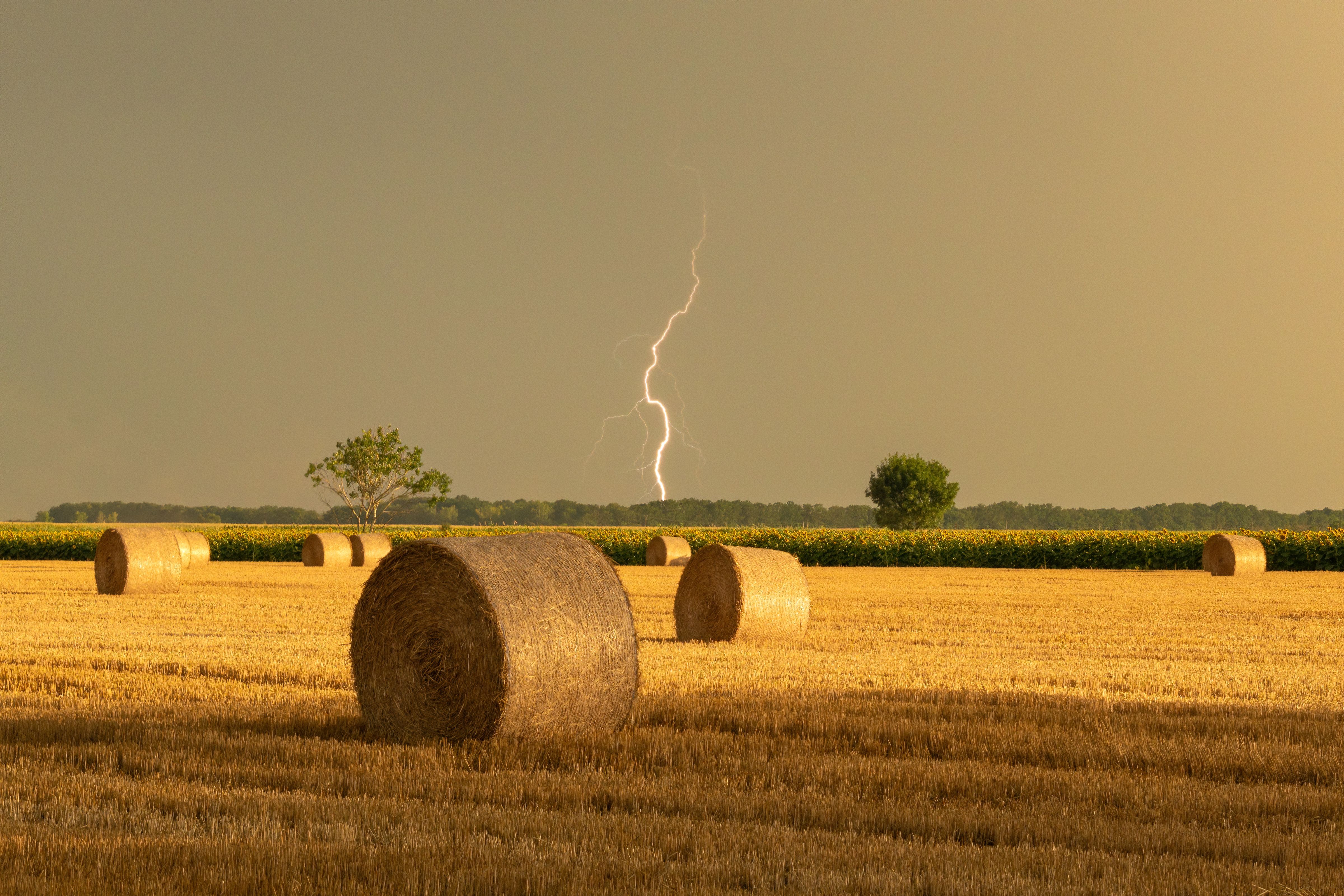 A Lightning above a Field with Hay Bales · Free Stock Photo