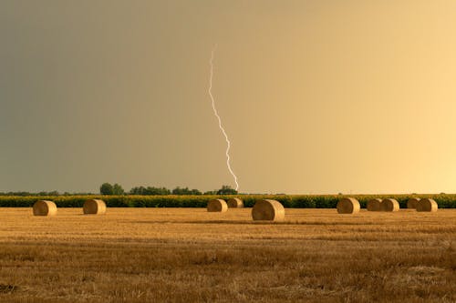 A Lightning above a Field with Hay Bales 