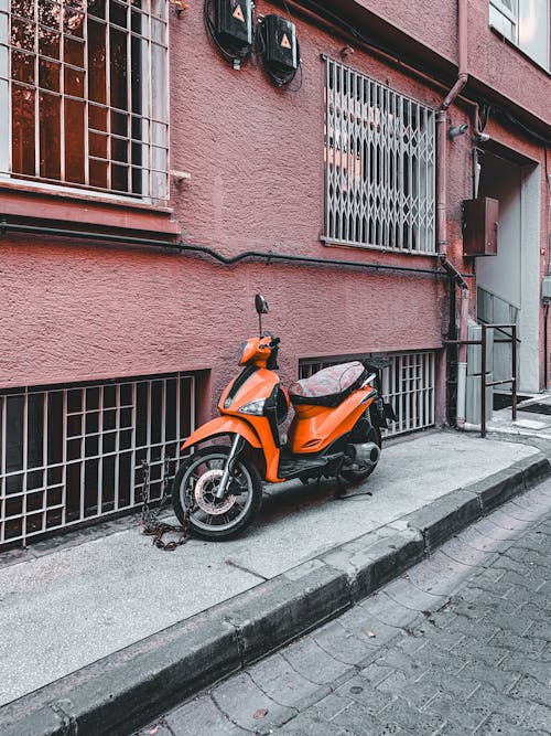 Motor Scooter Parked by Building Wall