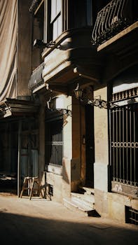 Charming urban architecture with ornate metalwork and vintage lamps in sunlight.