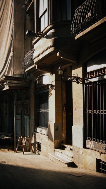 Charming urban architecture with ornate metalwork and vintage lamps in sunlight.