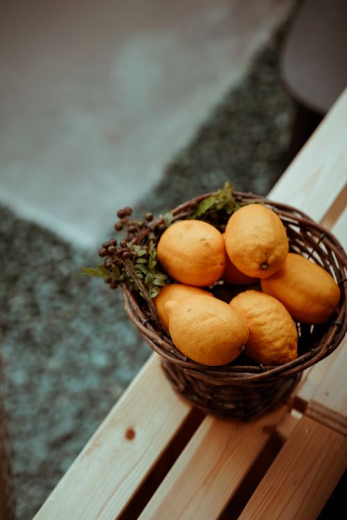 Free A vibrant basket of fresh lemons on a rustic wooden bench, embodying freshness and health. Stock Photo