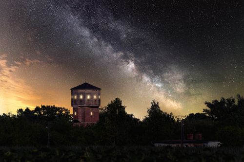 Free A stunning view of the Milky Way over a tower silhouetted against the evening sky. Stock Photo