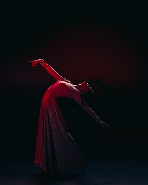 Dancer in a Long Dress on a Dark Stage