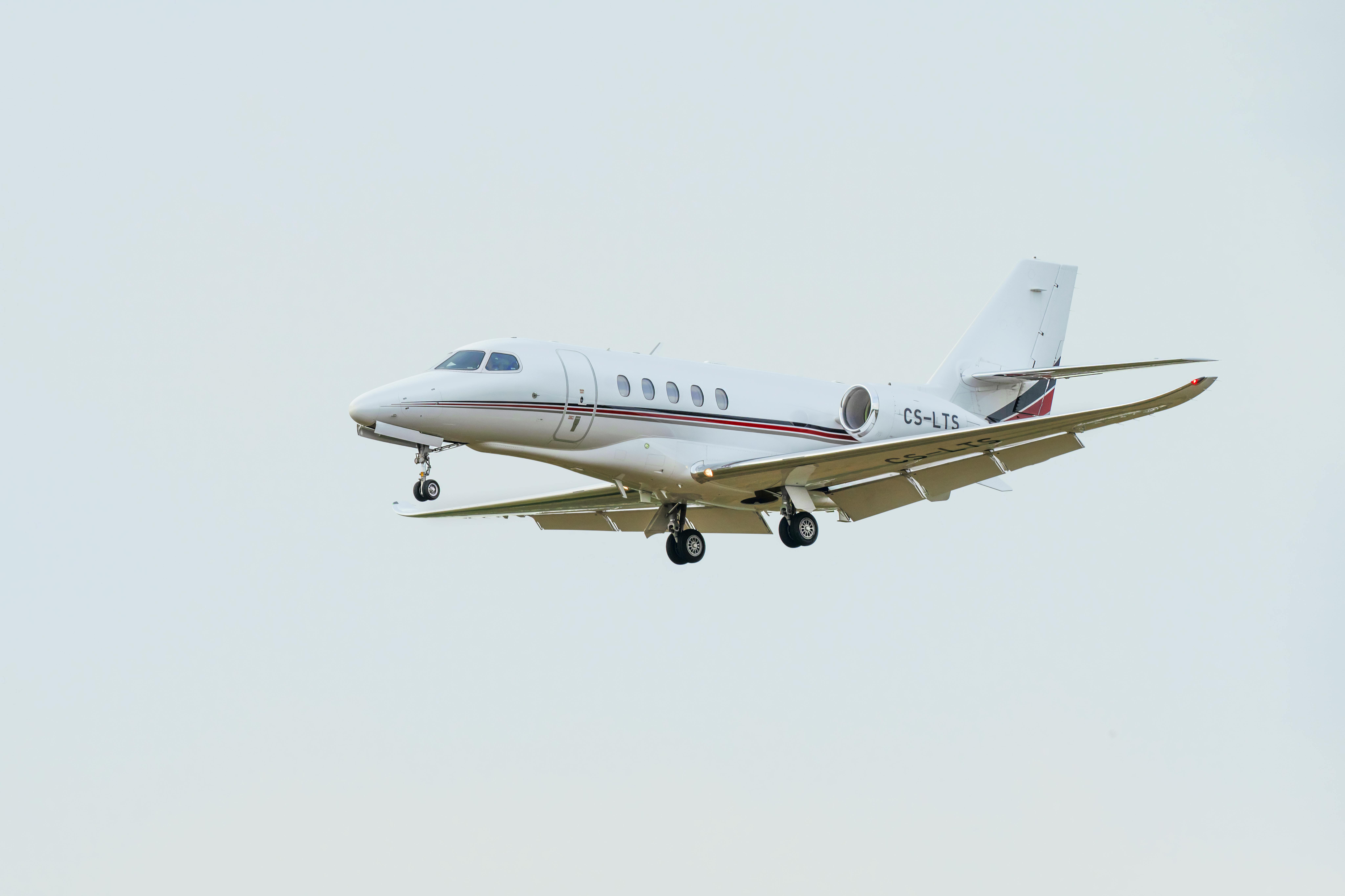 Free A modern white private jet flying in clear sky, showcasing aerial travel elegance. Stock Photo