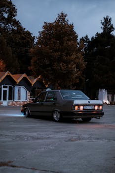 Old-fashioned car parked in a lot at twilight, evoking nostalgia.