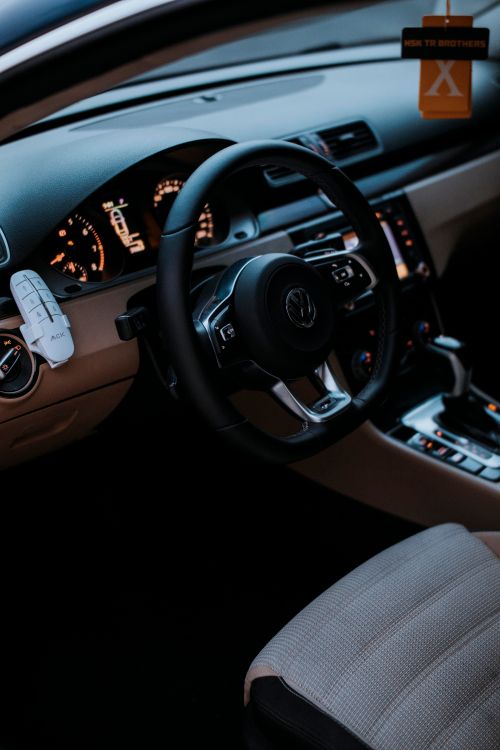 Free Interior view of a Volkswagen vehicle featuring a modern dashboard and steering wheel design. Stock Photo