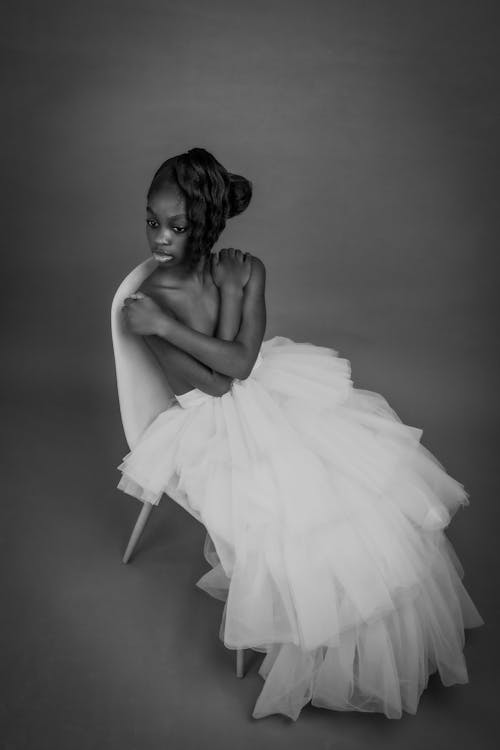 Studio Shot of a Young Woman Sitting Topless in a Tulle Skirt