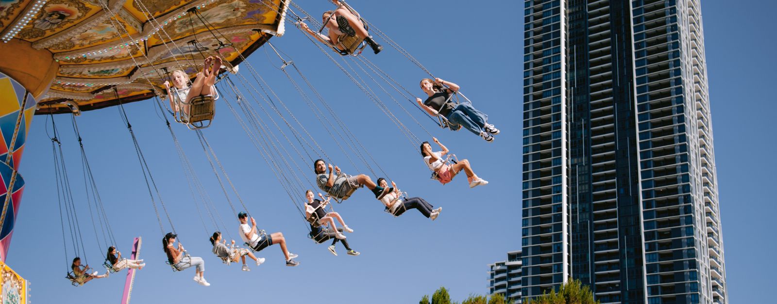 A thrilling amusement park ride with a skyscraper backdrop, capturing the essence of urban entertainment.