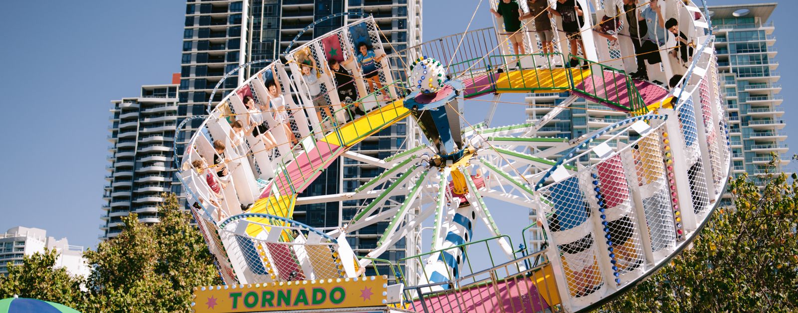 Exciting carnival ride set against city skyscrapers, capturing a lively urban atmosphere.