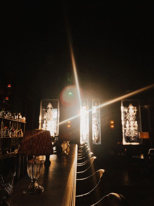 Free A dimly lit bar in Istanbul with sunlight streaming in, creating lens flares and reflections. Stock Photo