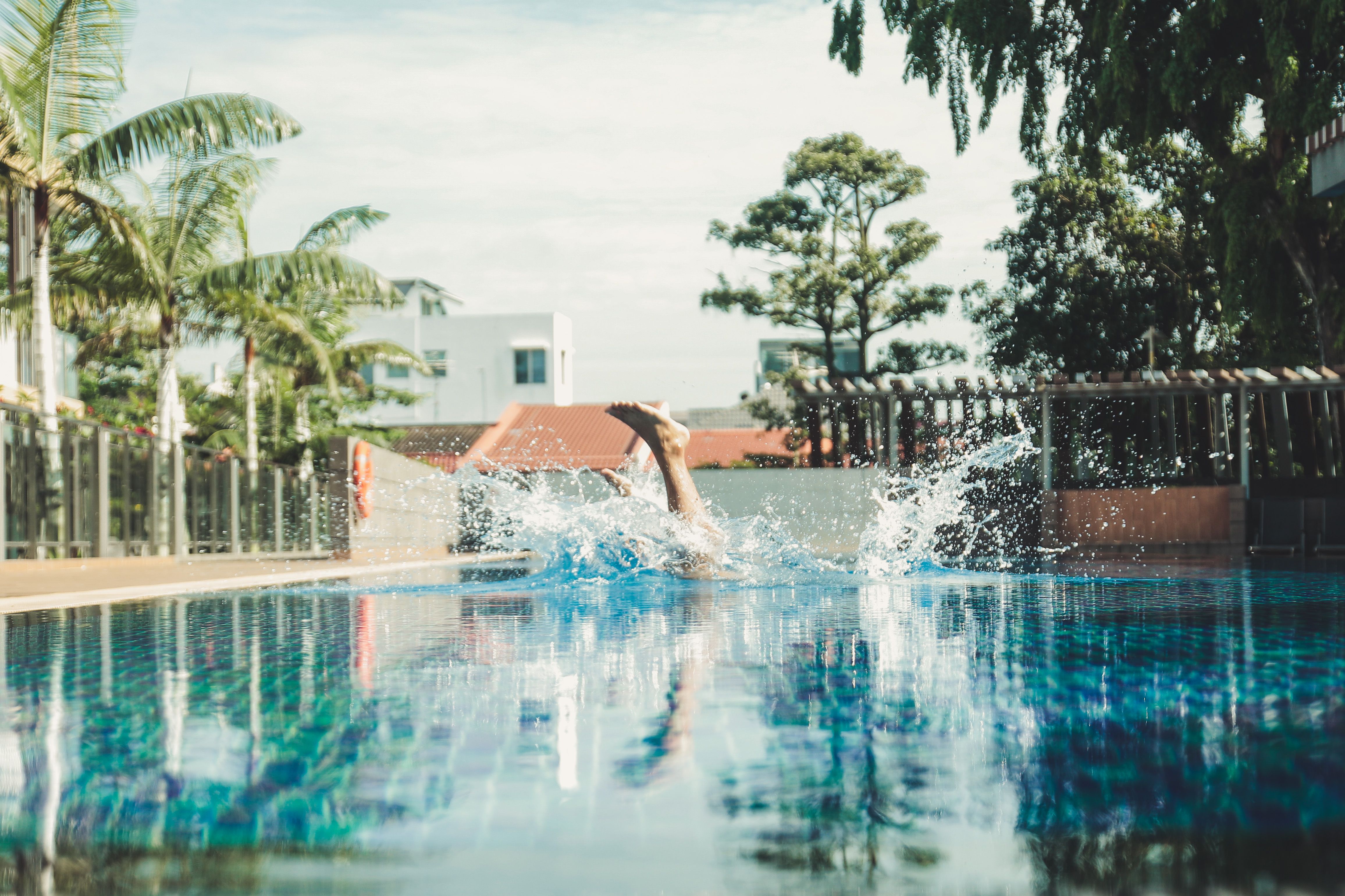 A splashy dive into a resort pool in Singapore captures the essence of summer fun and relaxation.