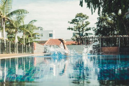 Free A splashy dive into a resort pool in Singapore captures the essence of summer fun and relaxation. Stock Photo