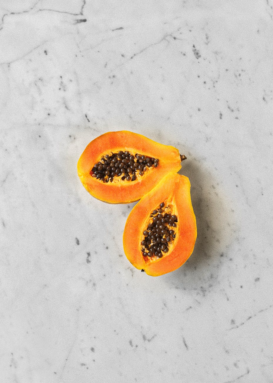 papaya sliced in half kept on a grey background