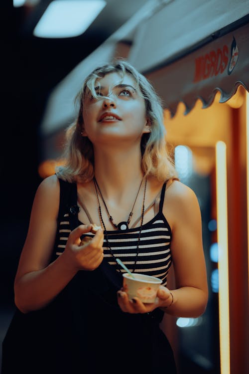 Young Woman with a Cup of Ice Cream Looking Up