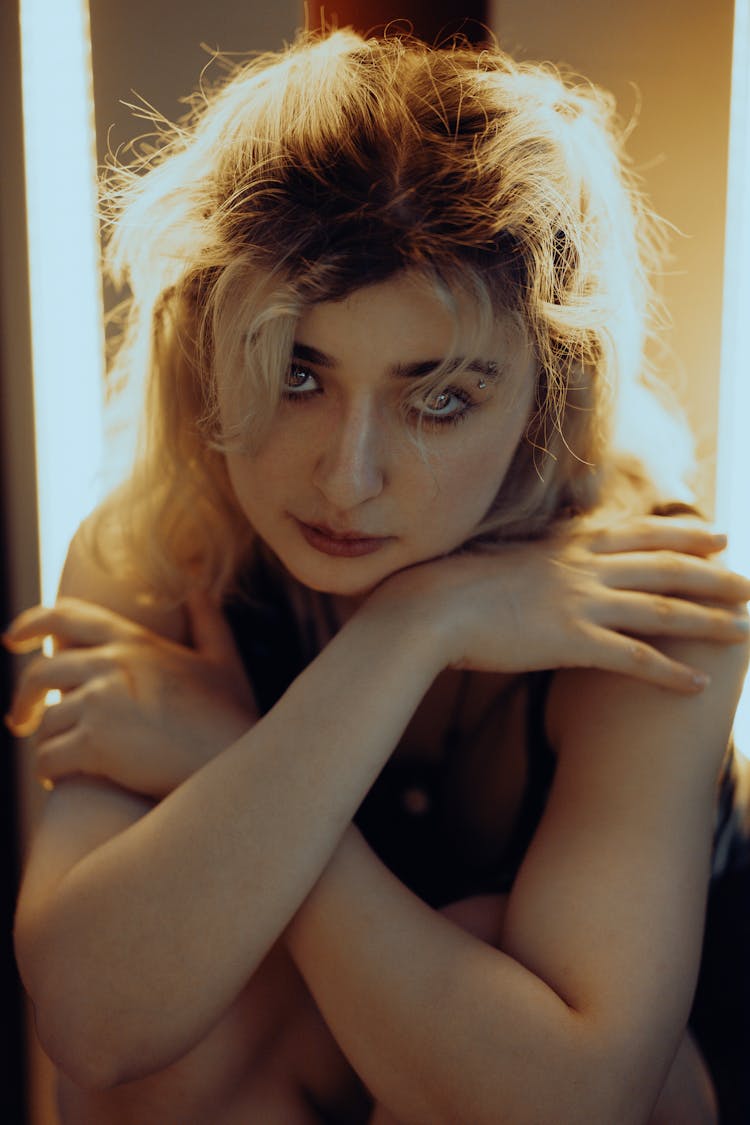 Young Woman Sitting With Arms Crossed 