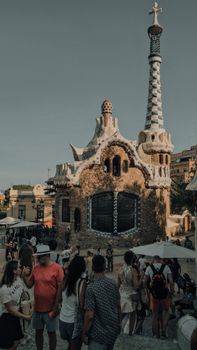 Tourists gather around the iconic Gaudí-designed structure in Park Güell, Barcelona.